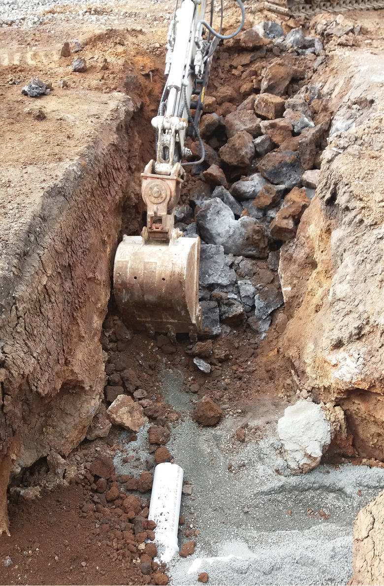 DIgger excavating dirt/ground for pipes.