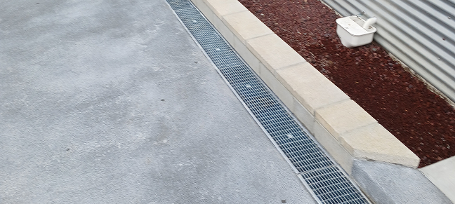 Driveway drainage channel installed to direct rainwater away from paved areas.