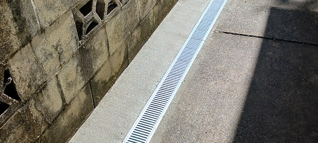 Driveway drainage channel installed to direct rainwater away from paved areas.