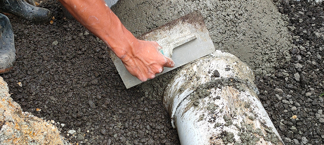 Person working on a flooding prevention solution using drainage tools.