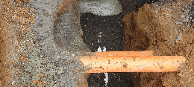 Orange drainage pipes underground.
