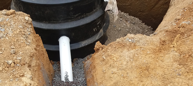 Waterpipe going into large black tank underground.