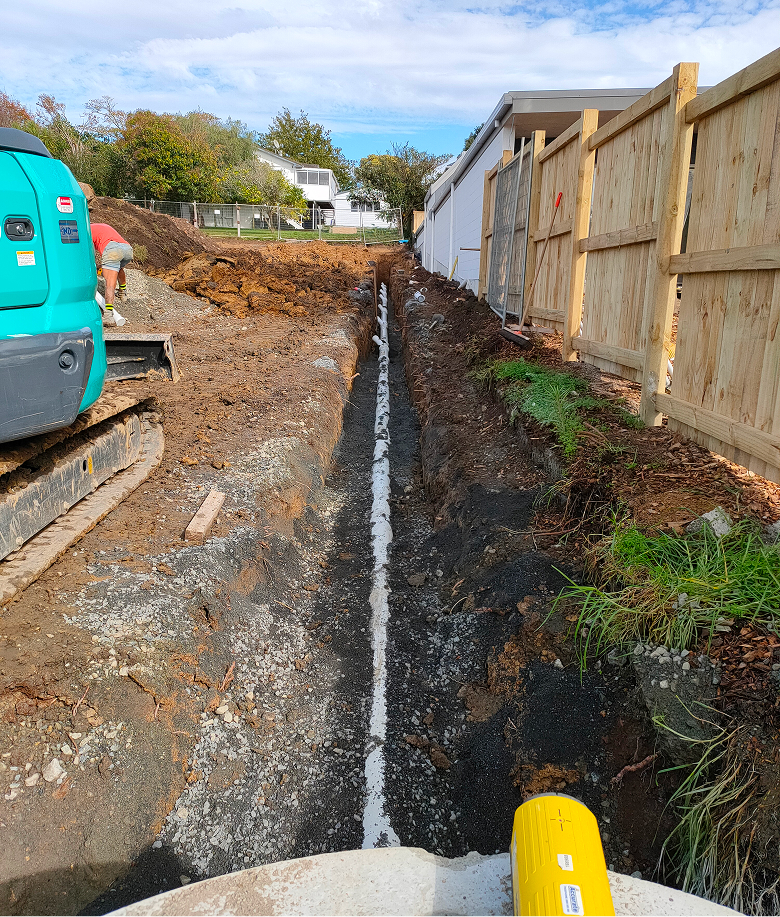 A buried pipe running through the ground with dirt packed around it