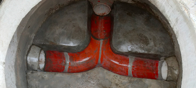 Top down view of waste water pipes underground.